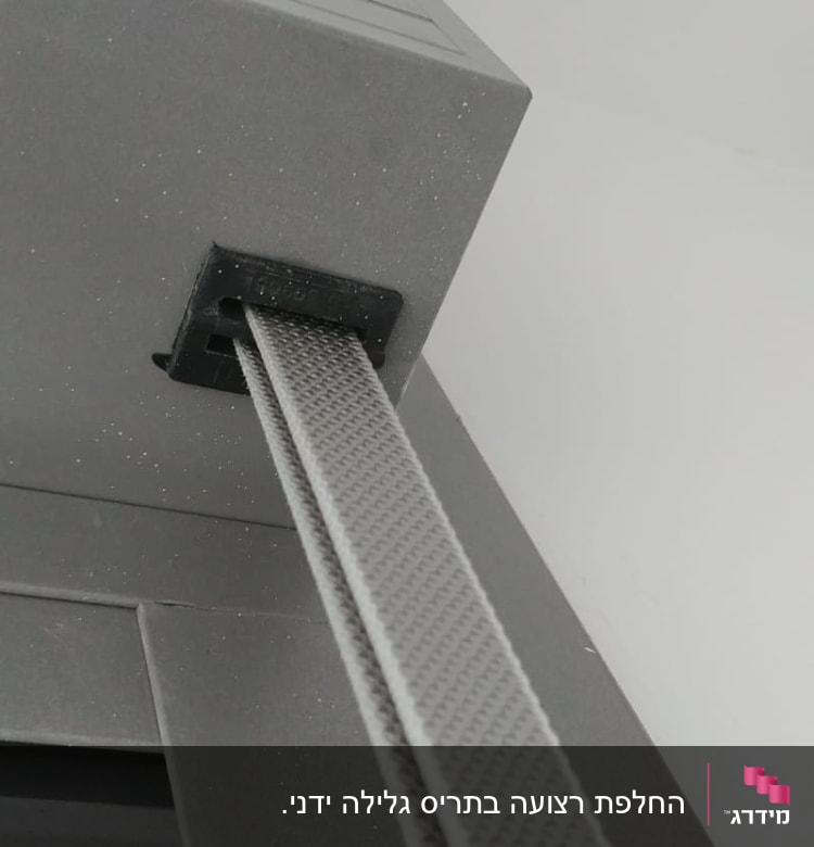 רצועת תריס אפורה מחוברת למסגרת מתכתית